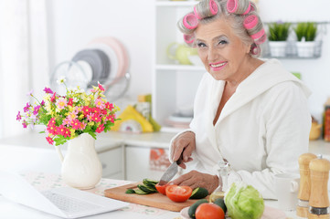 Senior woman in  hair rollers at kitchen