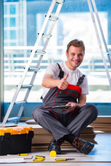 Man laying laminate flooring in construction concept