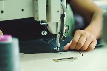 Women's hands behind her sewing.
