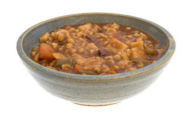 Bowl of canned beef stew on a white background.