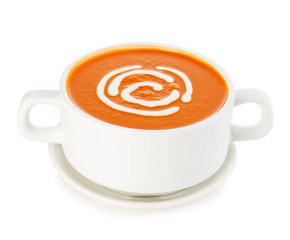 Delicious pumpkin and carrot soup with sour cream close-up isolated on a white background.