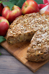 fresh apple pie in a cut on wooden board, top view