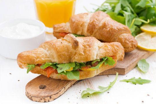 fresh croissant stuffed with fish and arugula for breakfast 