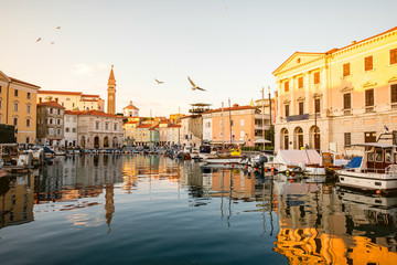 View on Piran medieval town from the bay with boats at the sunset in Slovenia