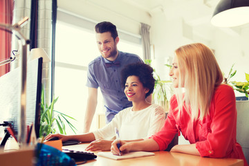 happy creative team with computer in office