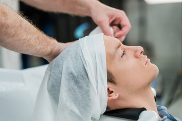 Obraz na płótnie Canvas Hairstylist washing client's hair in barber shop