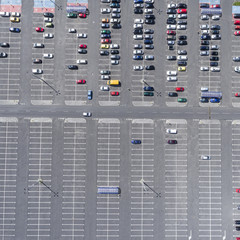 Supermarket roof and many cars in parking, viewed from above.