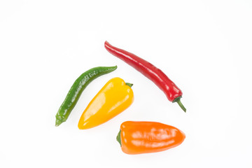 Bunter Chilischotenmix. Zwei längliche und zwei rundliche auf weissem Hintergrund.