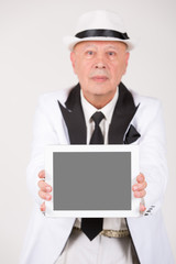 Senior in weißem Anzug hält Tablet / Computer mit Platz für Text / Symbol