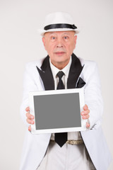 Senior in weißem Anzug hält Tablet / Computer mit Platz für Text / Symbol