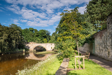 Fototapeta premium River Coquet flows under Warkworth Bridge, a medieval fortified bridge in Northumberland
