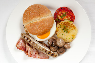 Traditional english breakfast with egg, ham, potato, sausage, to
