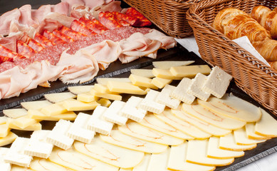 Cheese plate asorted with croissants and breakfast meat
