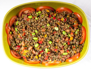 Fresh salad with beans and tomatoes in a green bowl