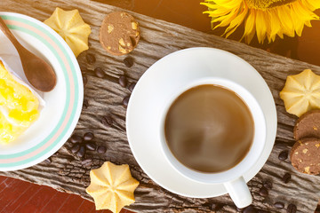 Coffee and flower with cookies on wood texture.