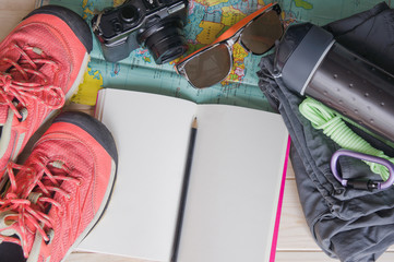 Top view of travel accessories for a mountain trip on old wooden background : hiking boots, pants,...