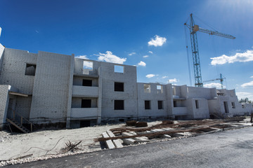 Fototapeta premium Crane construction bricks concrete building in city