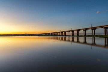 Fototapeta na wymiar Beautiful sunset scene of railway bridge in lake of pasak Dam ,