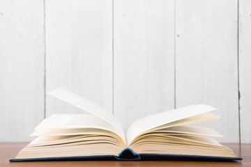 Open book on the desk over wooden background