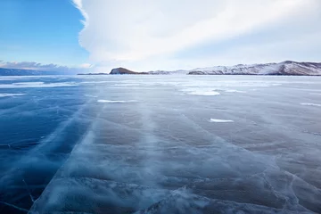 Tuinposter Winter ice landscape on lake Baikal with dramatic weather clouds © Serg Zastavkin