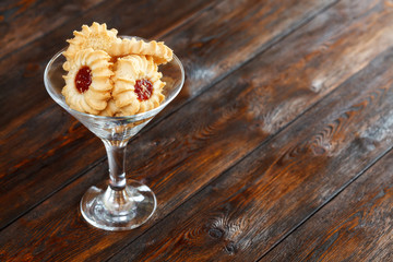 Glass with cookies on wooden background, copy space