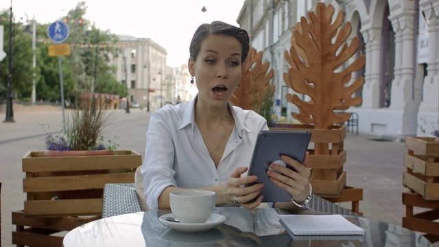 Talking to sweetheart. Young attractive lady talking per skype on new tablet.