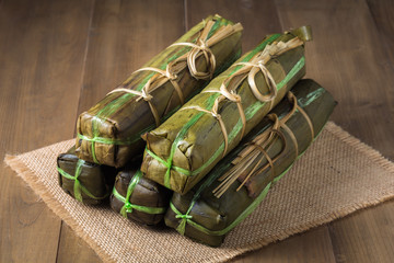 Vietnamese pork sausage steamed in banana leaf on wooden backgro