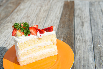 strawberry shot cake in orange dish on wooden table