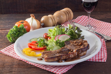 Kurobuta pork chop steak and vegetable on wooden table