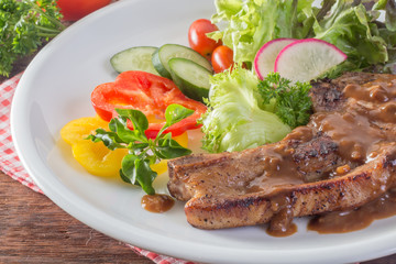 close up to Kurobuta pork chop steak and vegetable on wooden tab