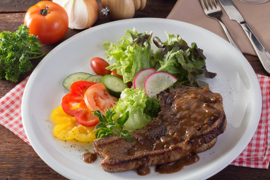 Kurobuta pork chop steak and vegetable on wooden table