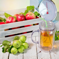 fresh juice and red apples in wooden box