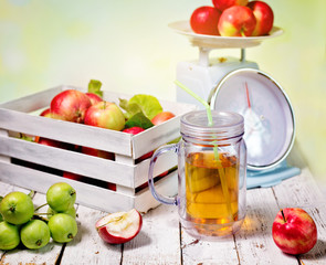 fresh juice and red apples in wooden box