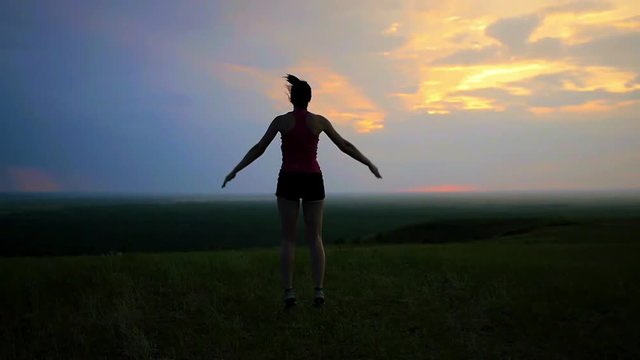 athlete warming up doing jumping exercises running on a sunset background