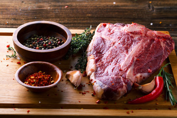 Raw fresh meat T-Bone Steak with herbs and spices and chilli pep