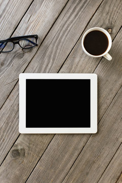 White Tablet With Blank Screen On Wooden Desk