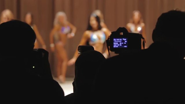 Many photographers using cameras to take pictures at fitness beauty contest