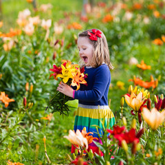 Little girl picking lilly flowers