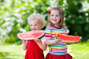 Kids eating watermelon in the garden