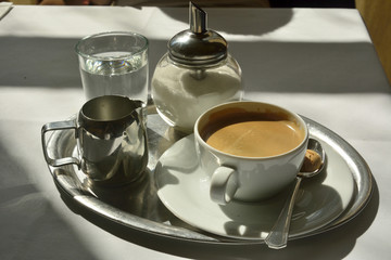 Coffee set with a cup of coffee, glass of water and sugarbowl. 