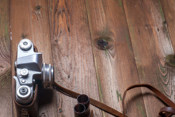 Old retro camera on vintage wooden boards abstract background. Copy space for text