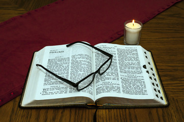Open Bible With Glasses and Candle