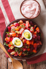 Finnish cuisine: rosolli salad and cream sauce close-up. Vertical top view
