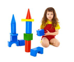 Child builds a toy castle on floor