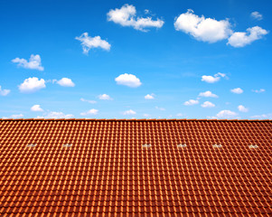 Obraz premium Roof house with red tiles on blue sky.