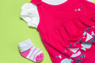 Clothes for baby girl on a pink background. Copy space for text
