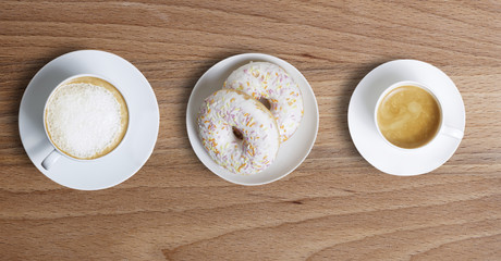 Two two cups of coffee and donuts