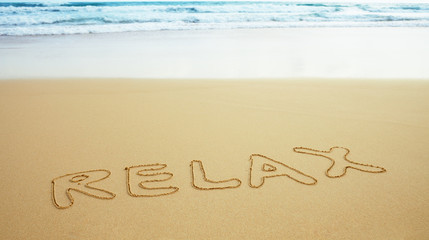 Inscription on beach sand - relax