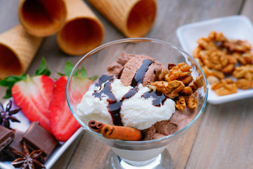 Ice cream sundae, chocolate, walnuts and sliced strawberry