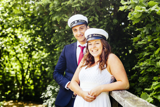 Portrait of happy male and female graduates against plants